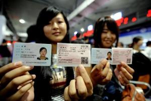     6月1日,两名旅客在沈阳北站展示自己的身份证和